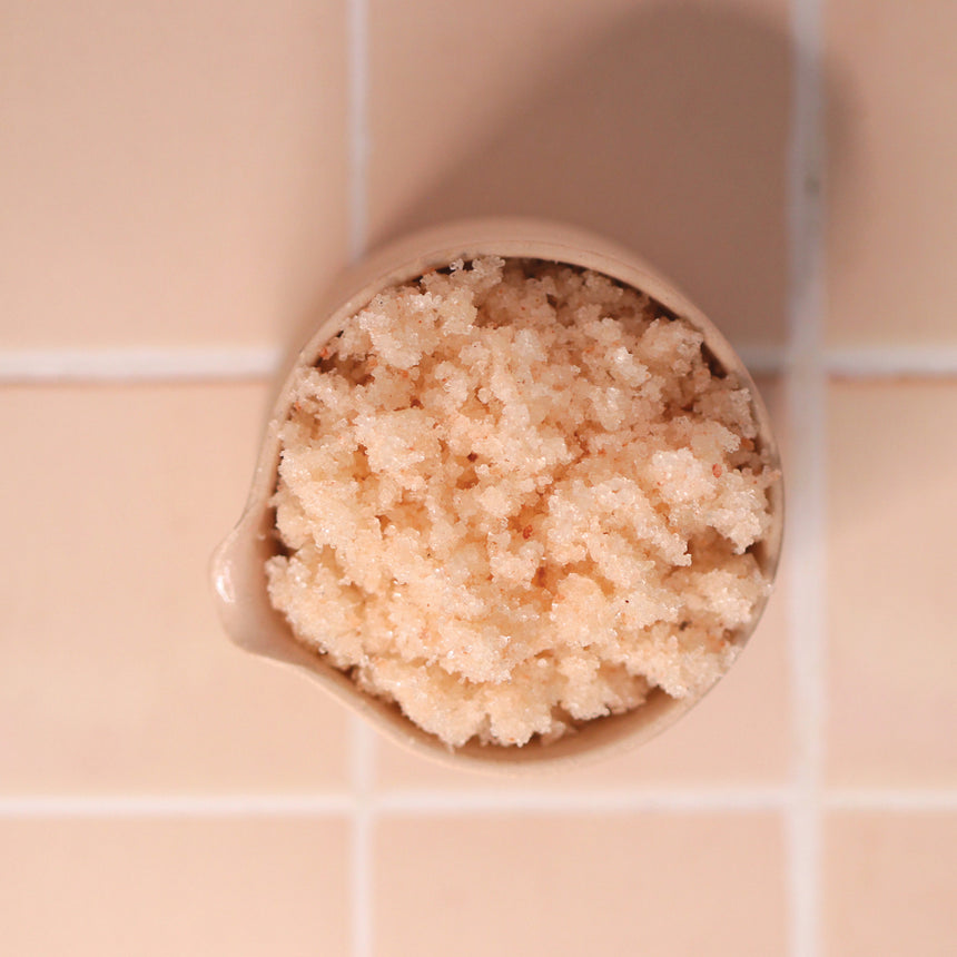 Naturlea Indulged Coconut Sugar Scrub crystals, pale pink colour, out of pack in ceramic jar. Your time to rejuvenate.
